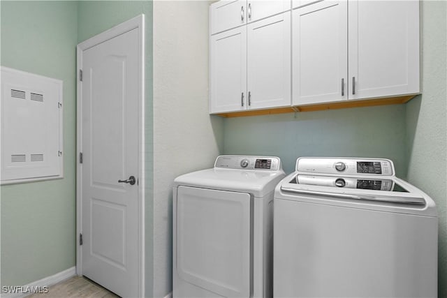 washroom featuring cabinets and washer and clothes dryer