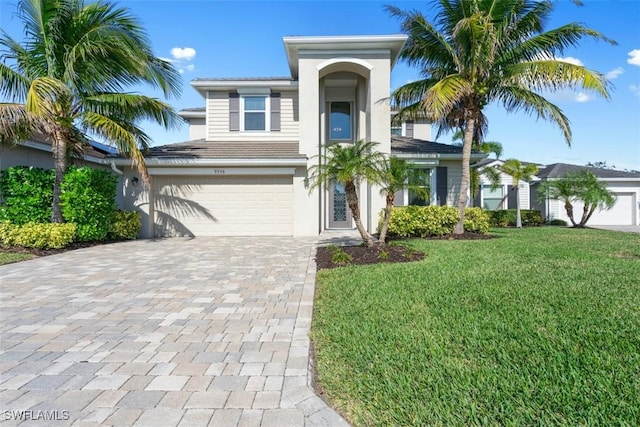 view of front of property with a front yard, an attached garage, and driveway