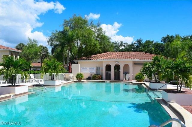 pool with a patio area and fence