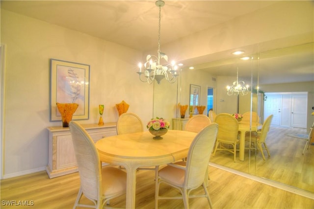 dining space with a notable chandelier and light hardwood / wood-style floors