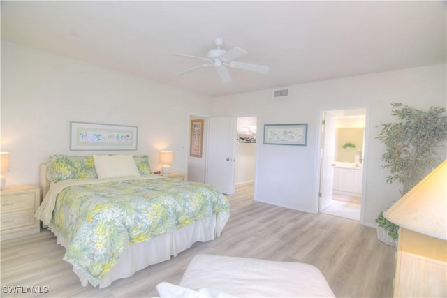 bedroom with ceiling fan, connected bathroom, light wood-style flooring, visible vents, and a spacious closet