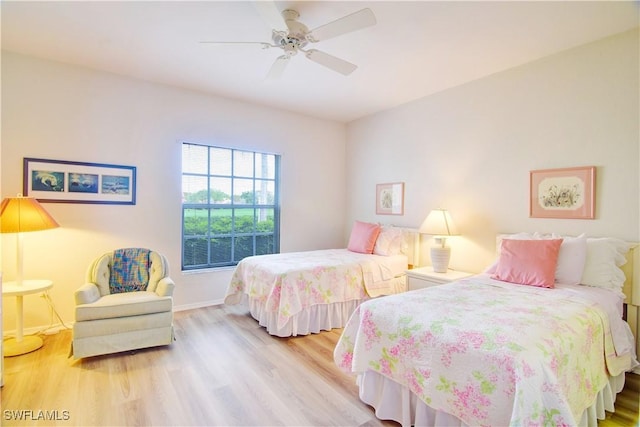 bedroom with ceiling fan, wood finished floors, and baseboards