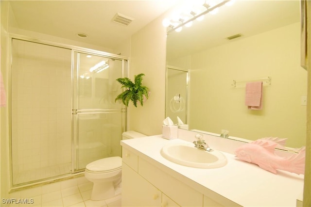 bathroom featuring tile patterned flooring, vanity, toilet, and walk in shower