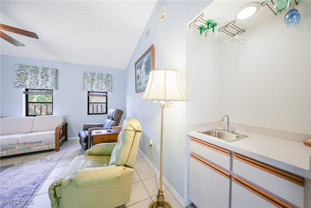 interior space featuring ceiling fan, sink, light tile patterned floors, and vaulted ceiling