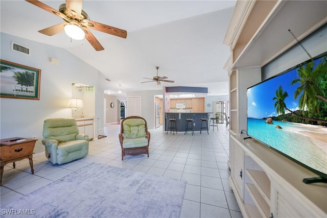 living room featuring ceiling fan, lofted ceiling, and light tile patterned floors