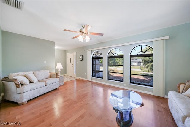 living room featuring light hardwood / wood-style floors and ceiling fan