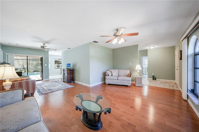 living room with ceiling fan and light hardwood / wood-style flooring