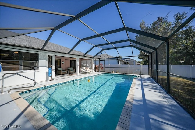 view of swimming pool featuring a patio, glass enclosure, and ceiling fan