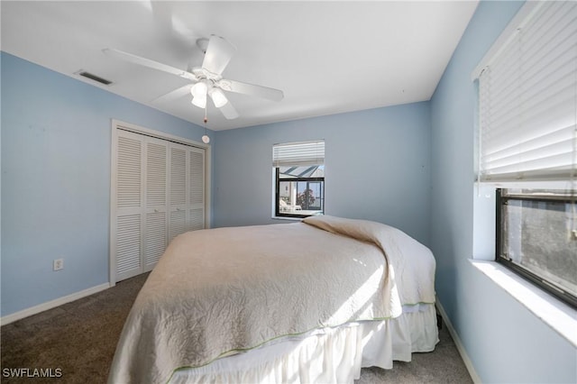 carpeted bedroom featuring ceiling fan and a closet