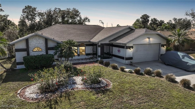 ranch-style house featuring a lawn and a garage