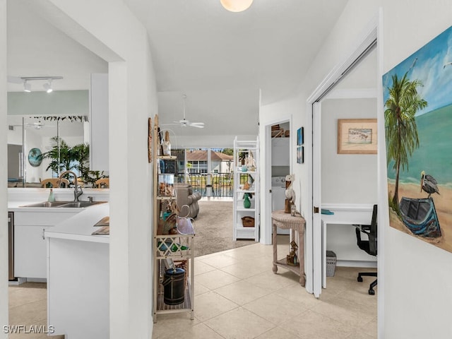 hall featuring light tile patterned floors and sink