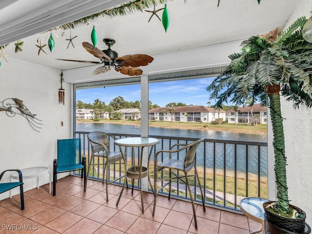 balcony with ceiling fan and a water view