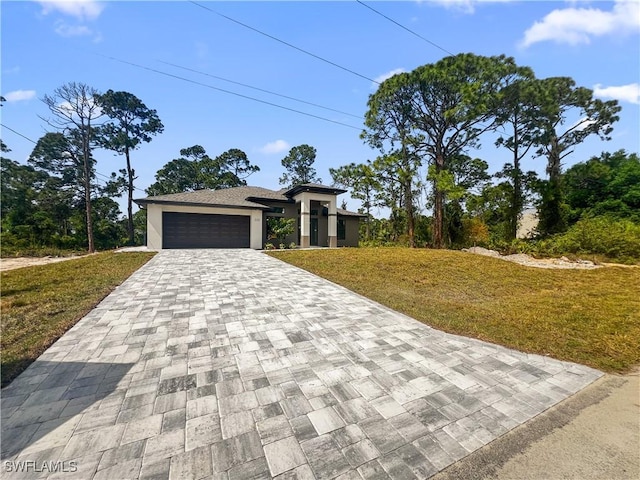 view of front of property with a front yard and a garage