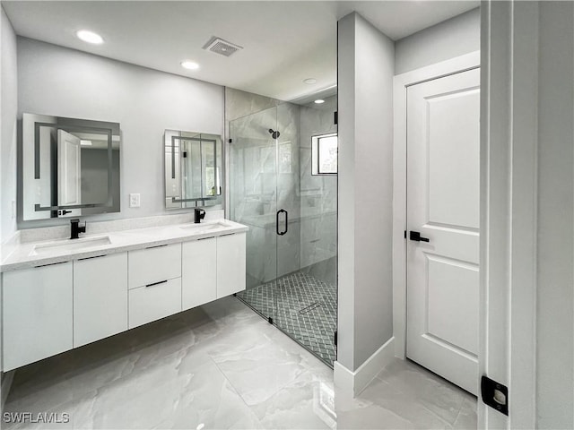 bathroom with vanity and a shower with door