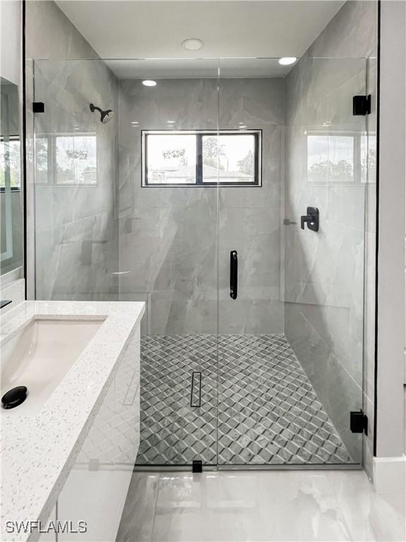 bathroom with sink and a shower with door