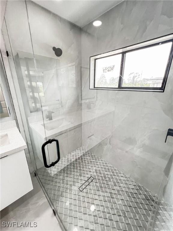 bathroom with vanity and a shower with door