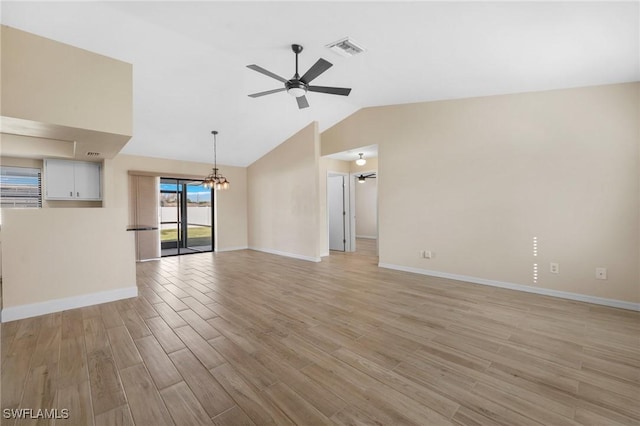 unfurnished living room with ceiling fan with notable chandelier, light wood-type flooring, and vaulted ceiling