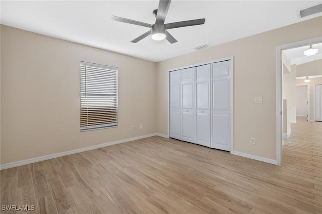 unfurnished bedroom with a closet, light hardwood / wood-style floors, and ceiling fan