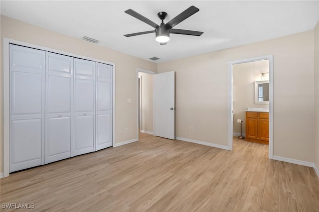 unfurnished bedroom featuring a closet, ensuite bathroom, ceiling fan, and light hardwood / wood-style floors