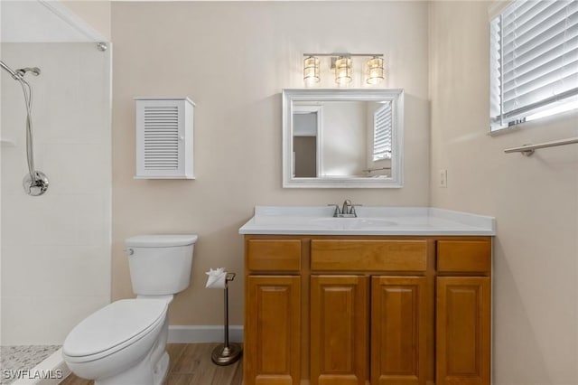 bathroom with hardwood / wood-style floors, vanity, toilet, and walk in shower