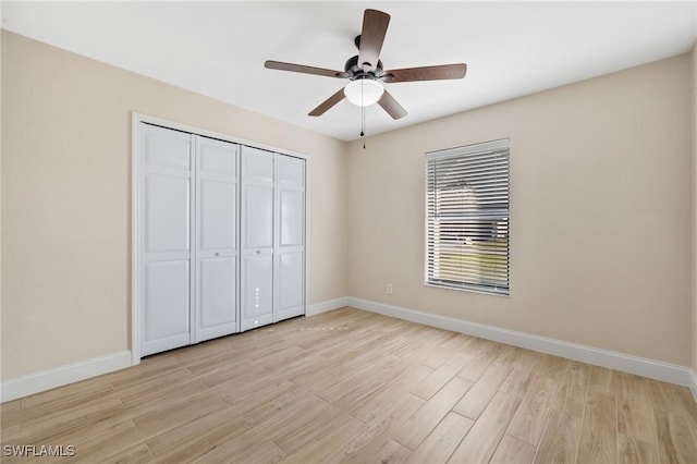 unfurnished bedroom with ceiling fan, a closet, and light wood-type flooring