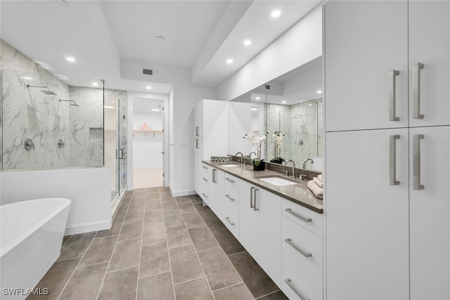 full bathroom with double vanity, a soaking tub, a sink, and a marble finish shower