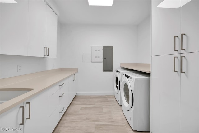 washroom with cabinets, electric panel, washer and clothes dryer, and sink