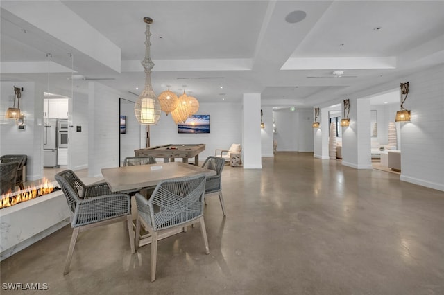 dining room featuring a ceiling fan, a tray ceiling, concrete floors, and baseboards