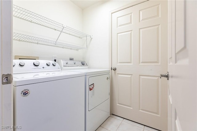 laundry room featuring light tile patterned floors and separate washer and dryer