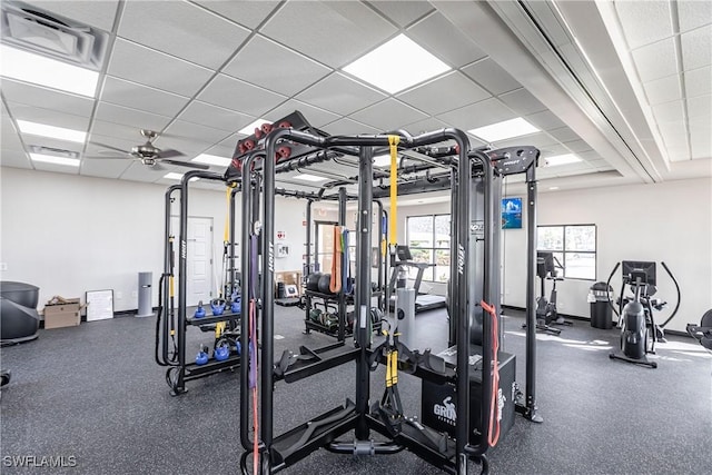 gym featuring ceiling fan and a drop ceiling