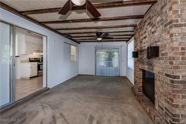 unfurnished living room featuring beam ceiling, ceiling fan, and a fireplace