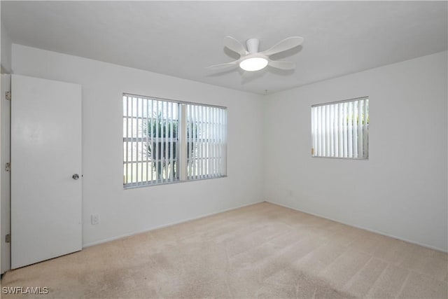 carpeted spare room with ceiling fan