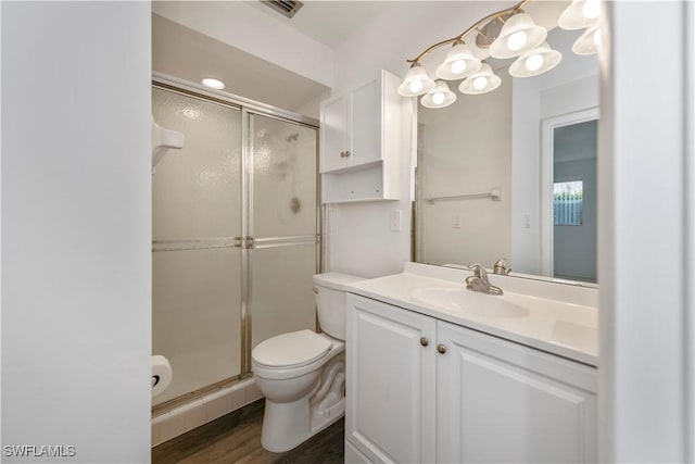 bathroom featuring hardwood / wood-style floors, vanity, toilet, and a shower with door