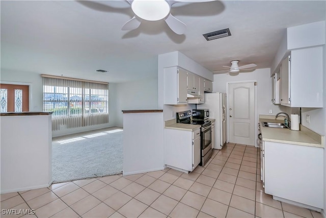 kitchen with electric stove, white cabinetry, sink, and light carpet