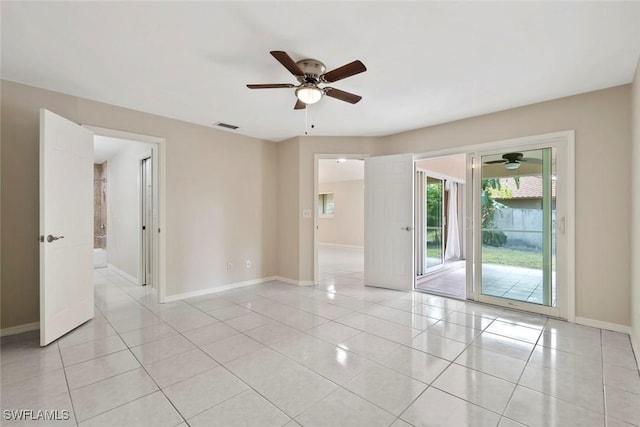 spare room with ceiling fan and light tile patterned floors