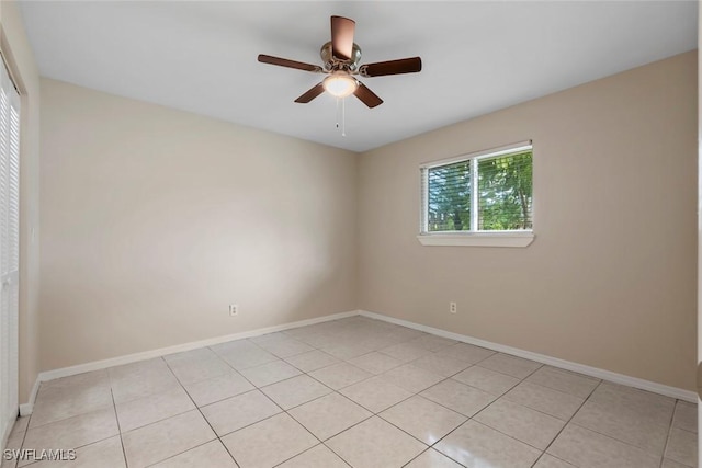 tiled empty room featuring ceiling fan