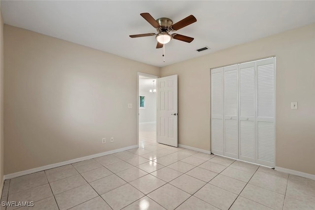 unfurnished bedroom featuring ceiling fan, light tile patterned floors, and a closet