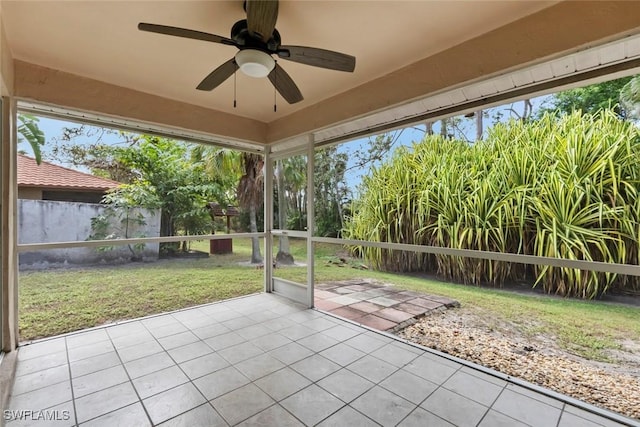 unfurnished sunroom with ceiling fan