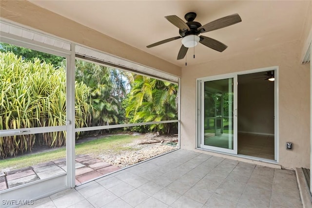 unfurnished sunroom with ceiling fan