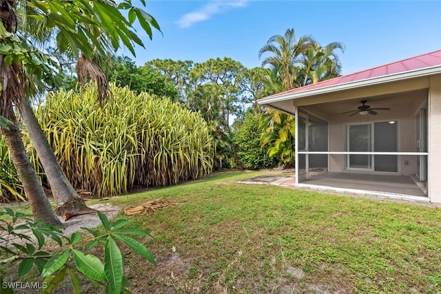 view of yard with a sunroom and ceiling fan