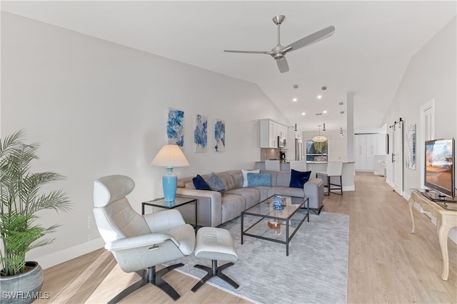 living room featuring lofted ceiling, light hardwood / wood-style floors, and ceiling fan