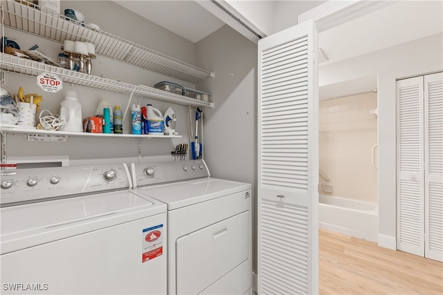 laundry room with washer and dryer and light hardwood / wood-style flooring