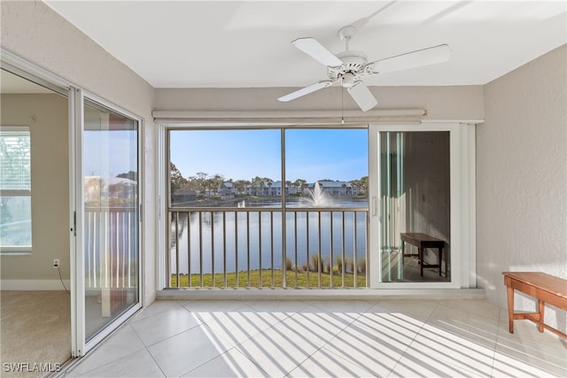 unfurnished sunroom with a water view and ceiling fan