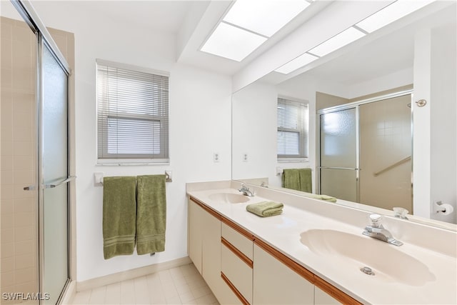 bathroom featuring walk in shower, tile patterned floors, vanity, and a skylight