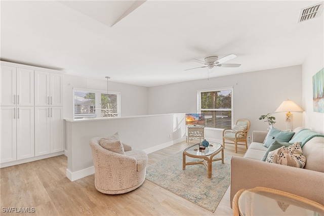 living room with light hardwood / wood-style flooring and ceiling fan