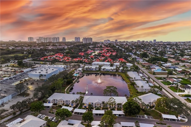 aerial view at dusk featuring a water view