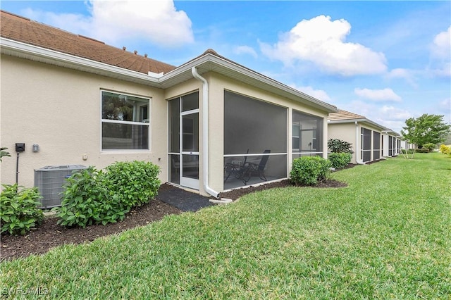 view of home's exterior with cooling unit, a sunroom, and a lawn