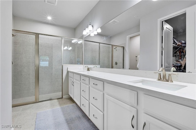 bathroom with tile patterned flooring, an enclosed shower, and vanity