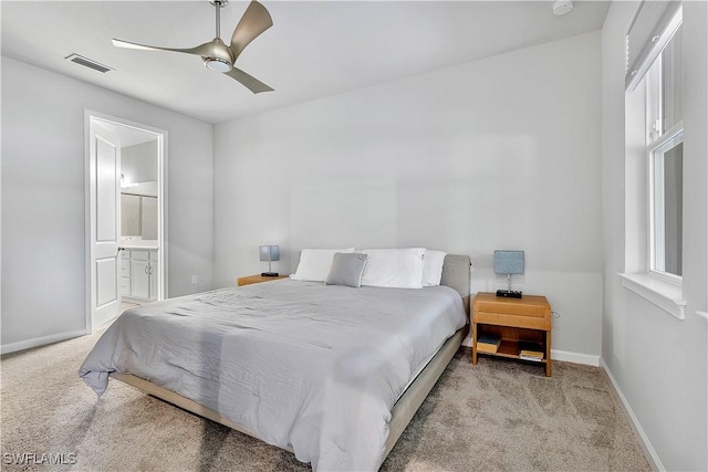 carpeted bedroom featuring ceiling fan and ensuite bath