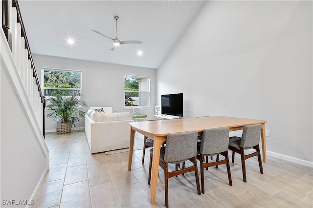 dining space with high vaulted ceiling and ceiling fan